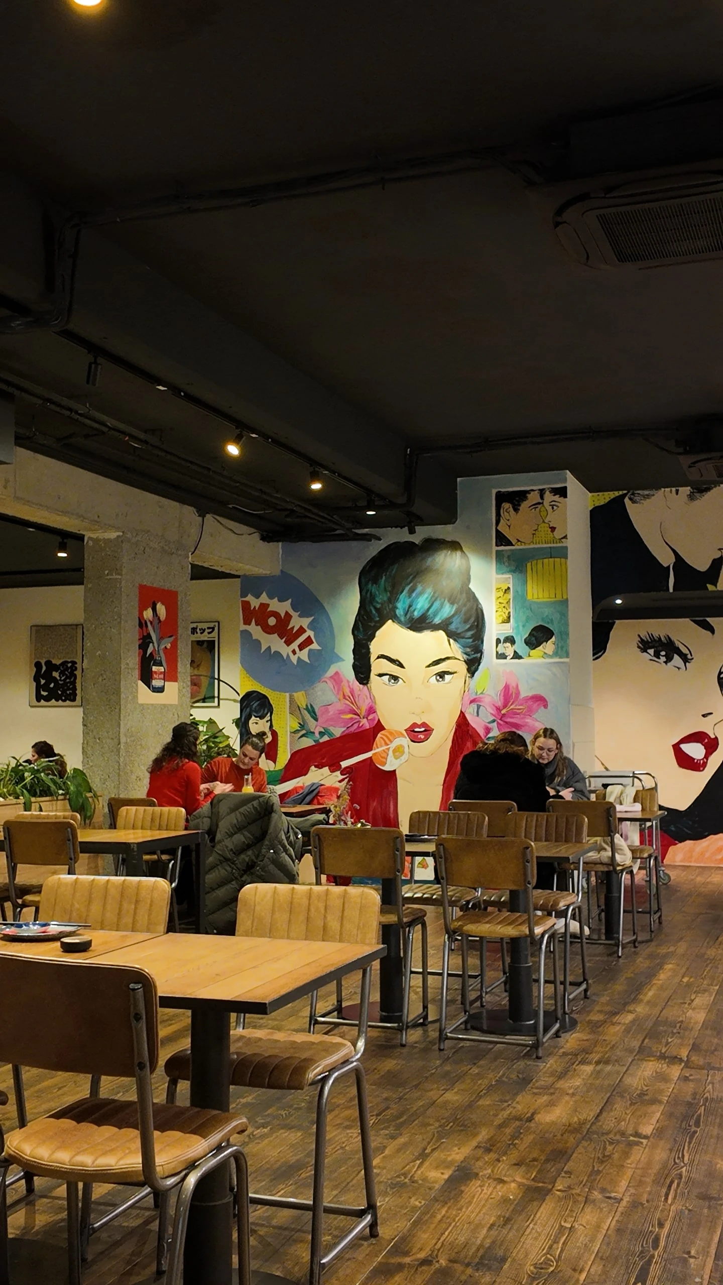 Restaurant Interieur mit Pop-Art Wandmalereien, Tischen und Stühlen
